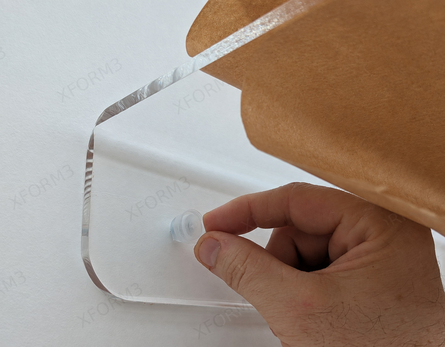 Pressing the clear acrylic cover cap over a secured screw